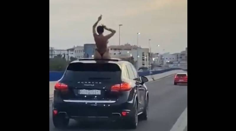 <span style='color:#780948'>ARCHIVED</span> - Woman fined after she is caught on video dancing on top of a car in a bikini on the motorway in Marbella, Spain