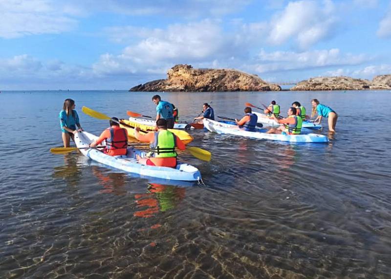 Day care patients with intellectual difficulties enjoy a day of paddle surfing at the beach in Puerto de Mazarrón